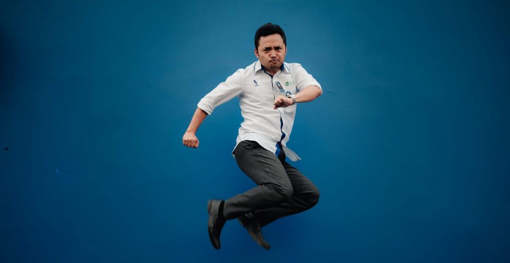 Man jumping in front of blue background