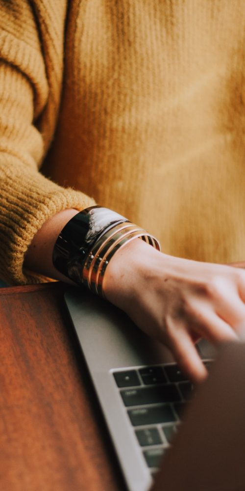 Hands typing on laptop